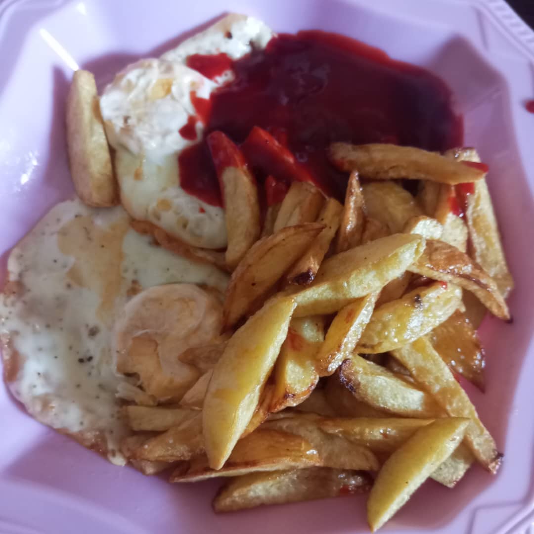 Fried Potato Chips with Sunny Side Up Eggs and Ketchup